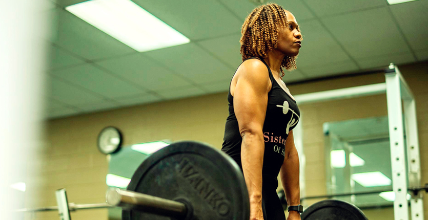 Strong woman lifting heavy weights in gym